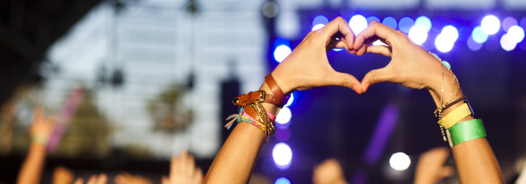 Person i publik på koncert gör hjärta med händerna
