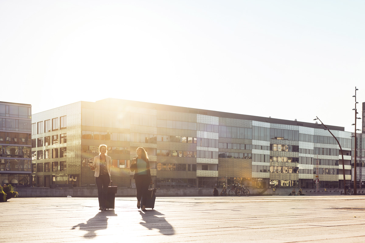 Två kvinnor drar resväskor i Malmö city