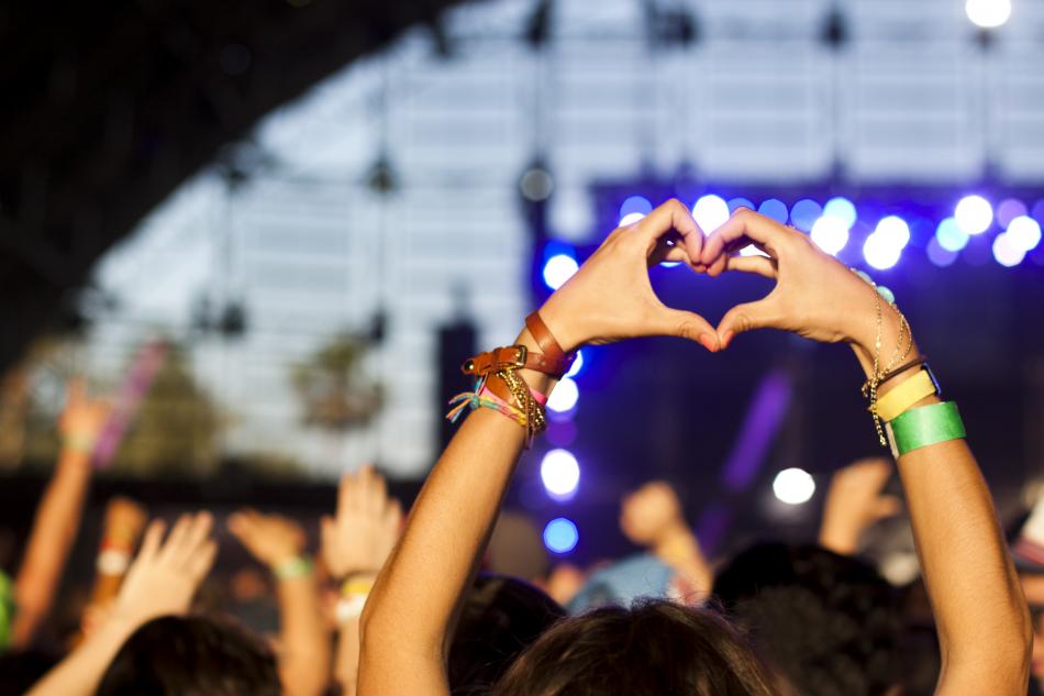 Person gör hjärtsymbol med händer under koncert
