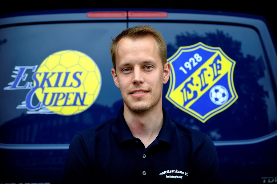 André Petersson står framför en bil med logotyper för Eskilscupen. Foto.